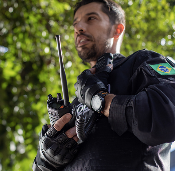 Image of male police officer handling a 2 way radio and advertisement to announce q2 2025 earnings