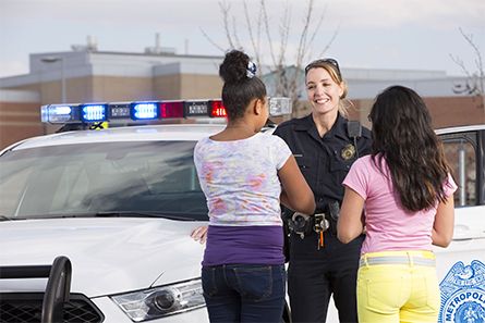 Police officer and civilian walking through a community