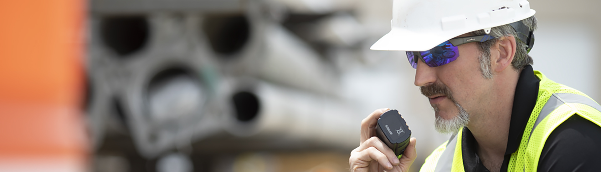 man in hardhat talking on a radio